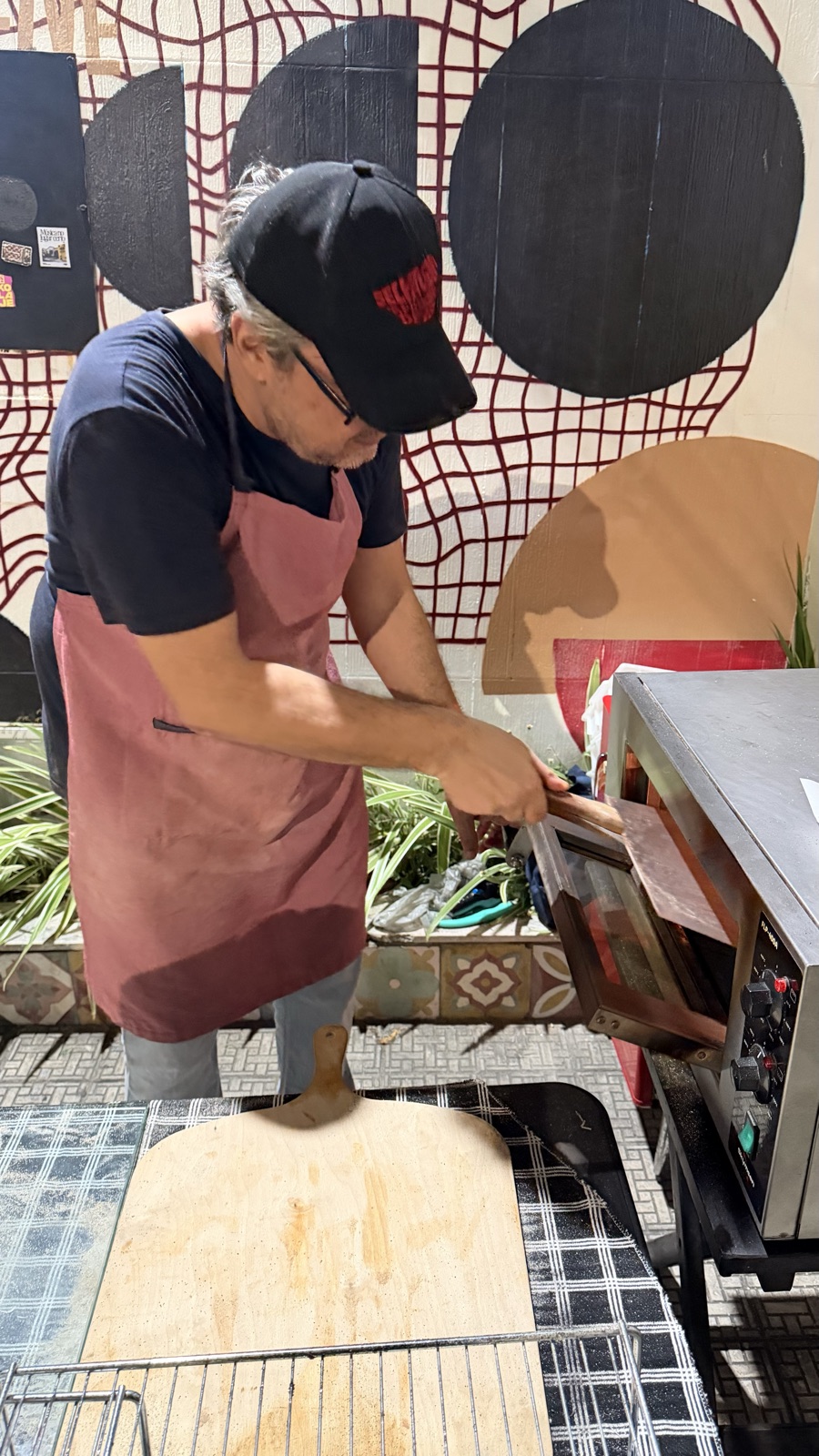 O pizzaiolo trabalhando no forno da banca