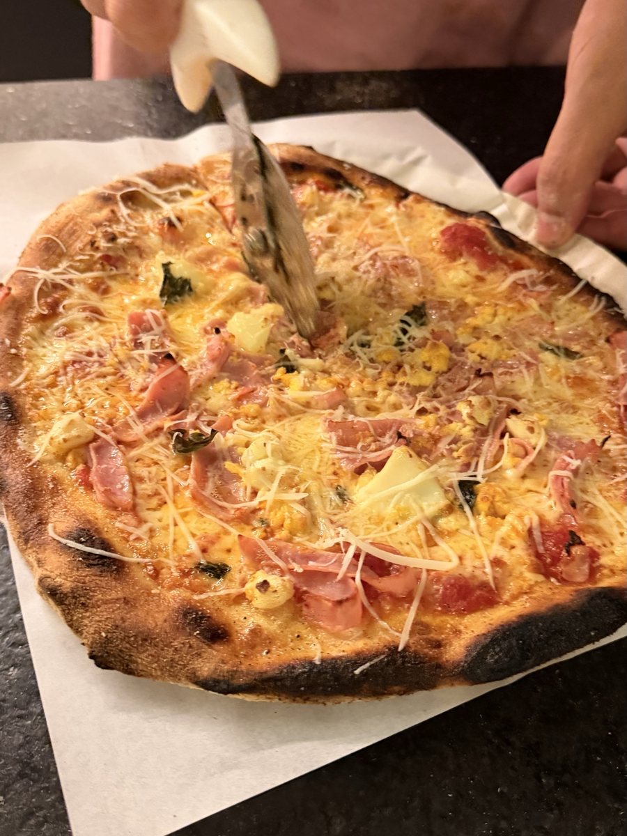 Pizza sendo cortada com o cortador de roda