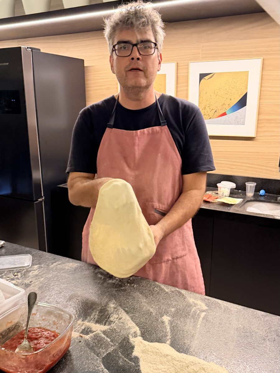 O pizzaiolo levantando o disco de massa aberto