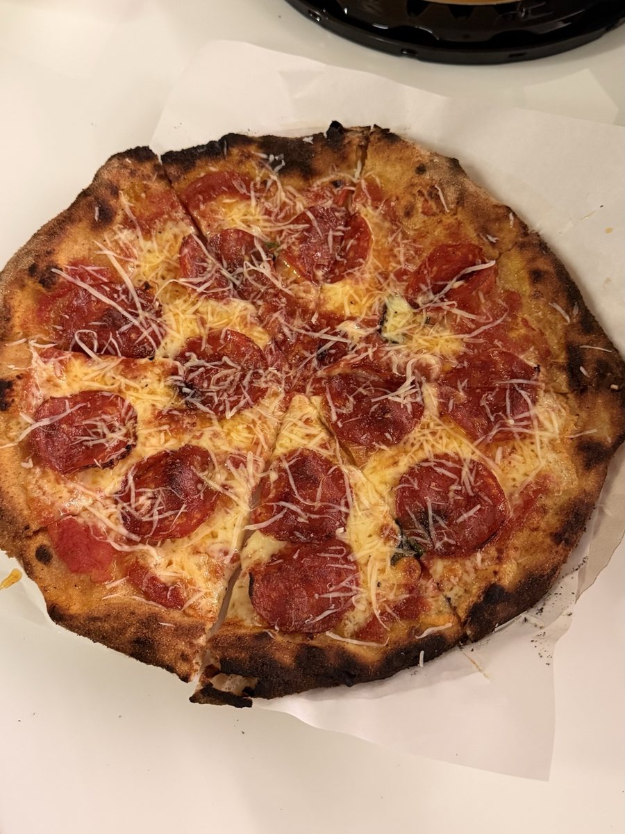 Pizza de pepperoni inteira sobre o papel