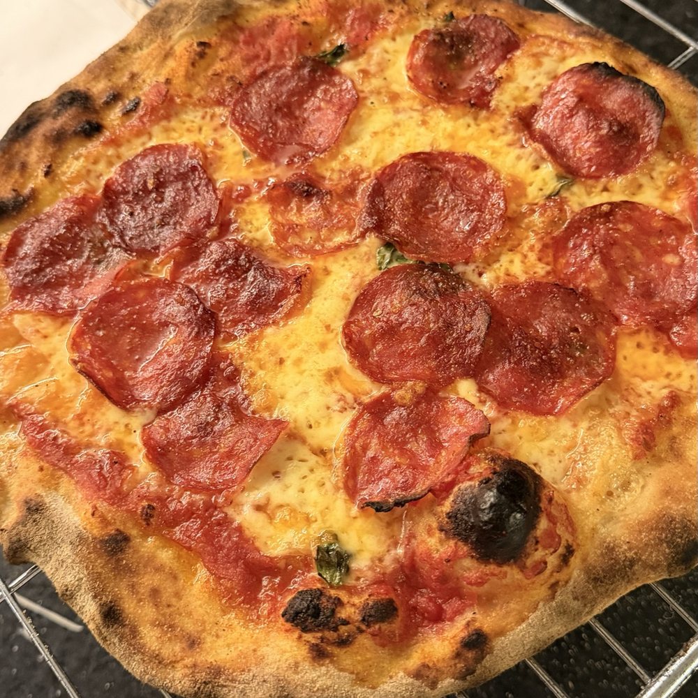 Pizza de pepperoni com as fatias encaracoladas pelo calor