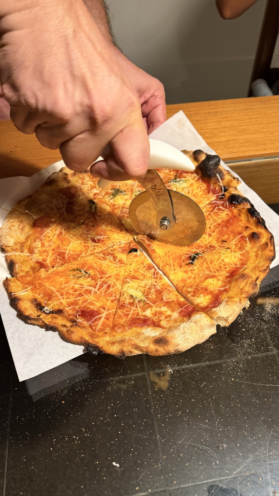 Pizza sendo fatiada com cortador