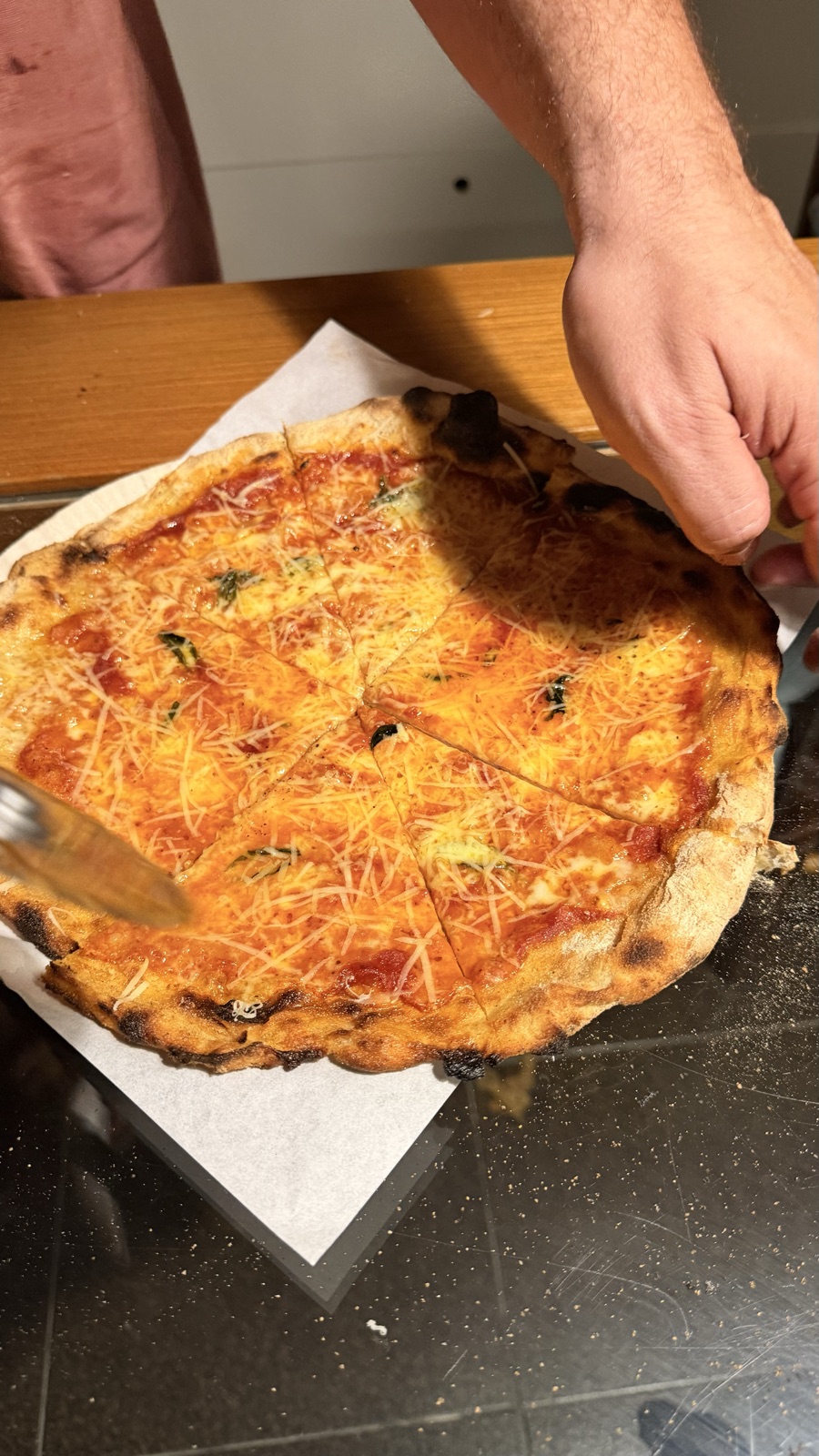 Pizza recém-assada sendo fatiada