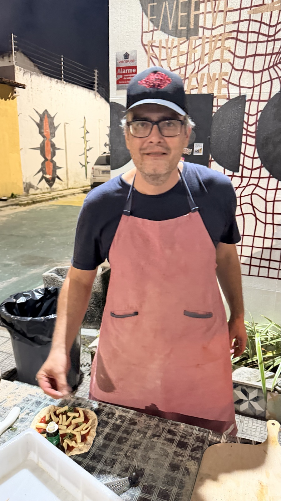 O pizzaiolo da Tomolino na banca, de avental, pronto para o serviço